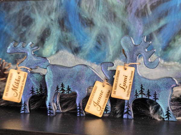 Set aus drei handgefertigten Resin-Deko-Elchen – Janne, Mikka und Lumi – mit schimmernden Polarlichtern, perfekte Winter- und Weihnachtsdeko.